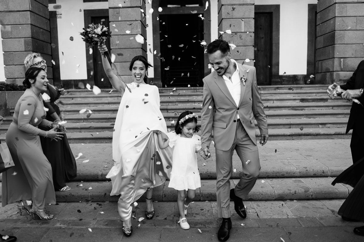 Novios saliendo del ayuntamiento entre pétalos tras la boda civil, fotografía en blanco y negro