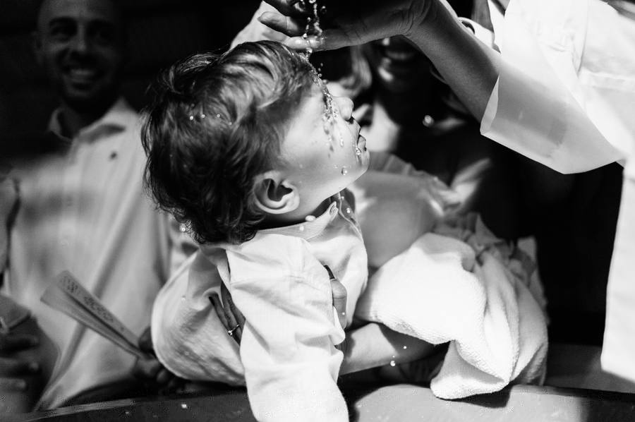 Fotógrafo de bautizos en Madrid capturando el momento del agua bautismal en blanco y negro