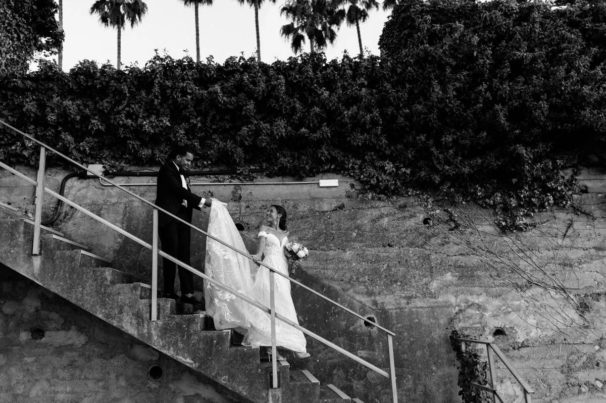 Novios sentados y abrazados en unas escaleras de piedra, retrato intimo en blanco y negro