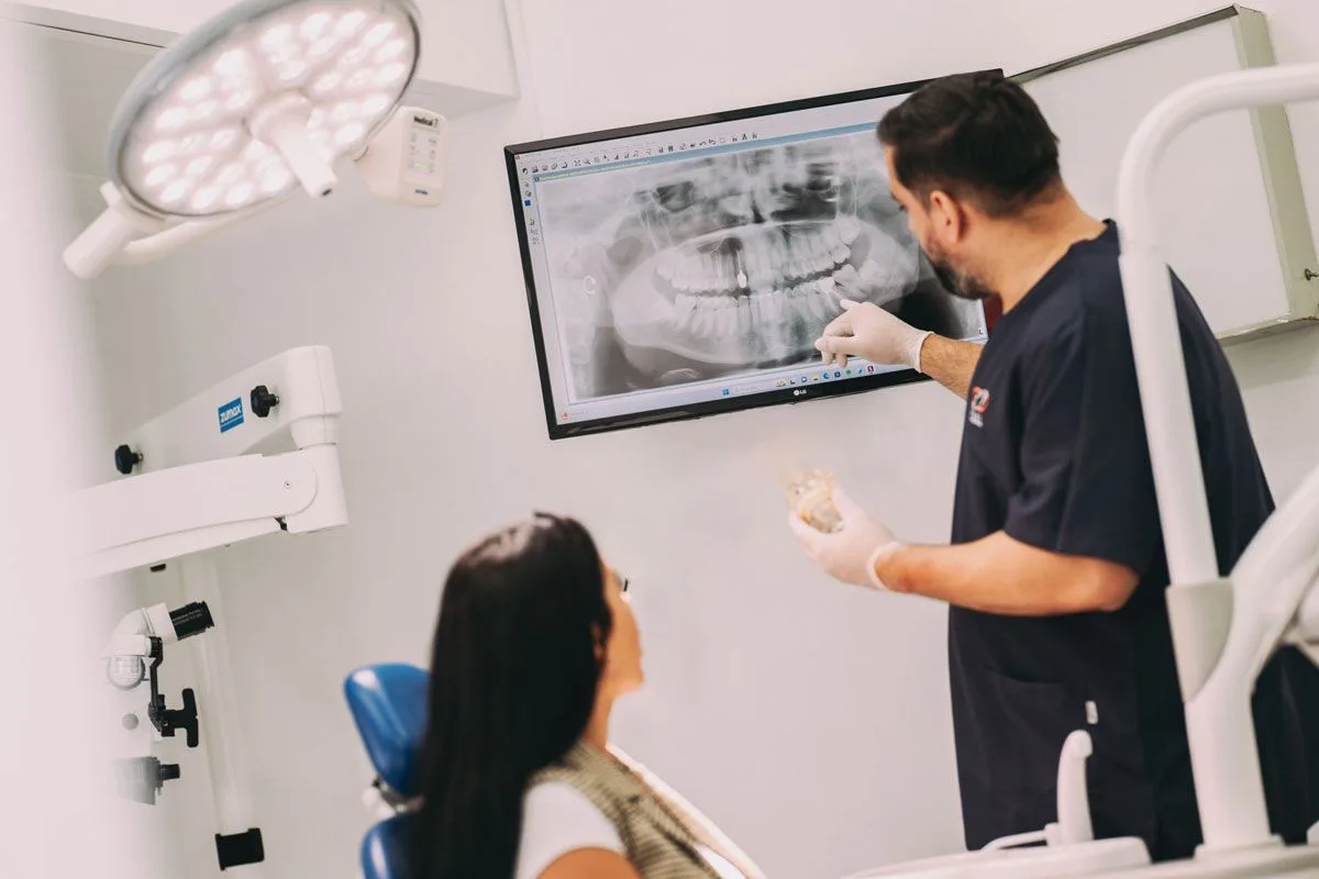 Dentista mostrando una radiografia a una paciente en la consulta, fotografia documental para clinica