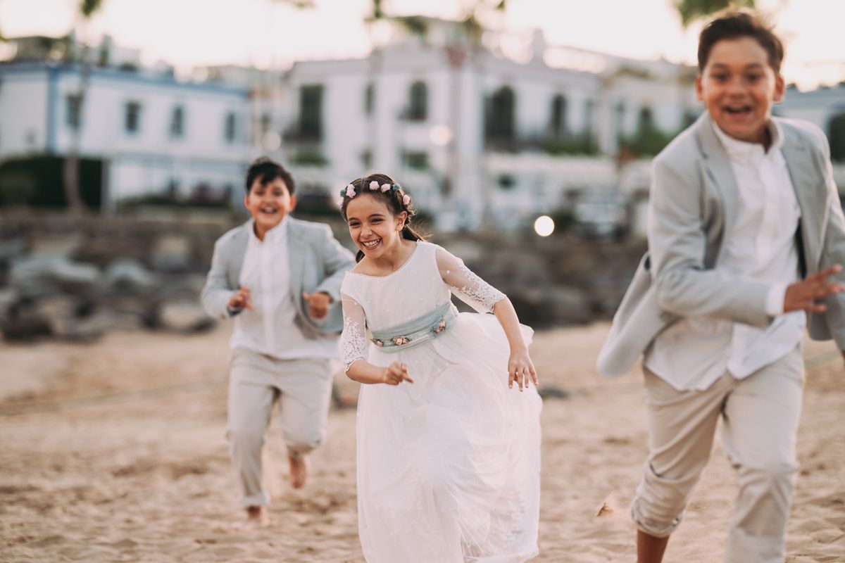 Niños corriendo y riendo el día de la comunión junto al mar
