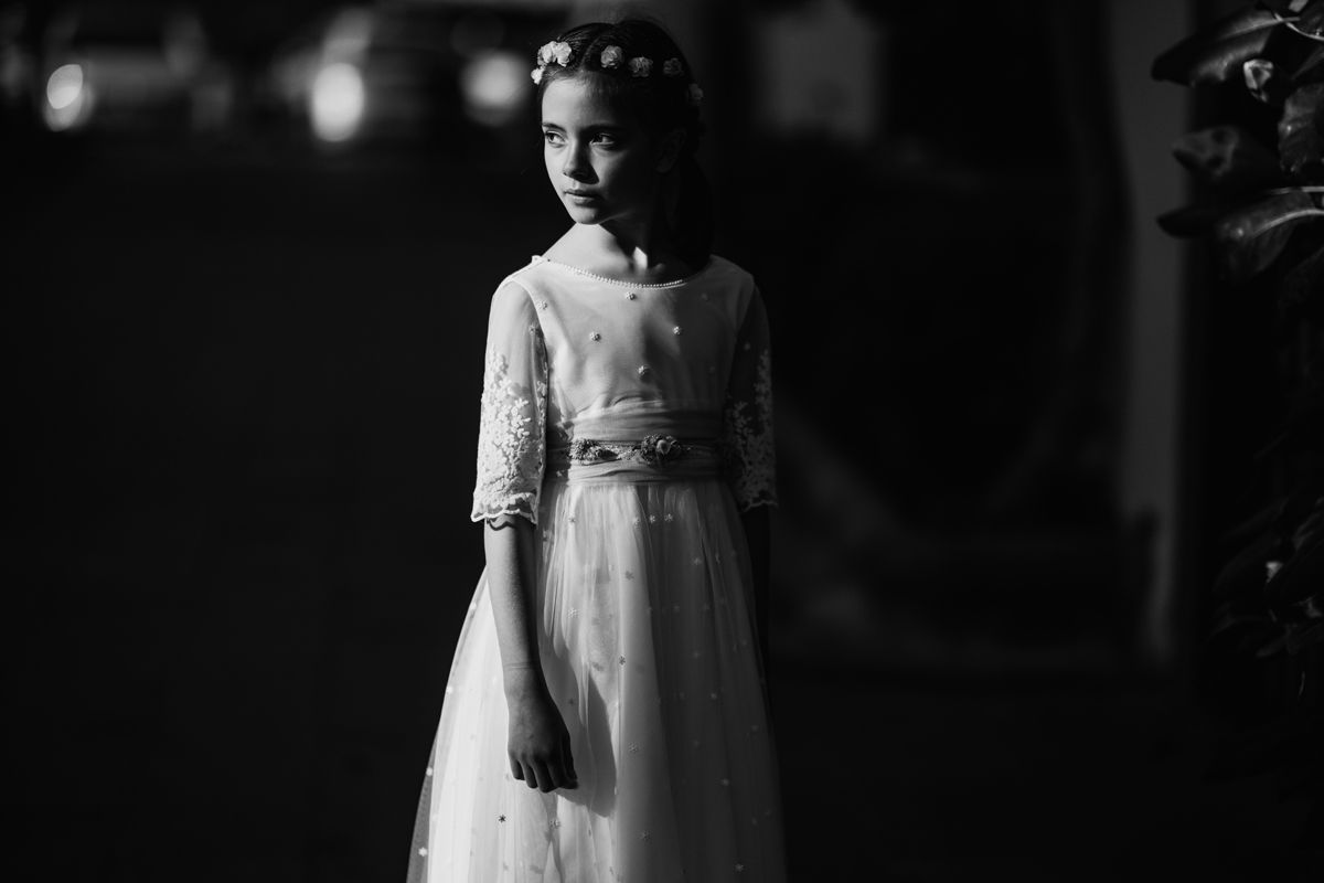 Retrato nocturno en blanco y negro de una niña de comunión con luz dramática lateral